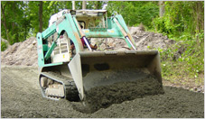 Track Laoder Spreading Gravel on Construction Driveway